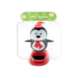 Solar Dancing Christmas Dashboard Toy featuring a cheerful penguin wobbler with a hat and scarf.