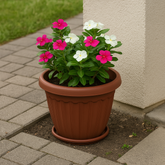 🪴 Terracotta-Style Plastic Planter with Saucer – 4 Sizes Available holding vibrant flowers on a patio.