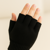 Knitted Fingerless Gloves – Black on a hand, showcasing the snug fit and fingerless design for warmth and functionality.