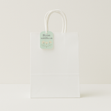 🛍️ Premium Paper Gift Bags – 4-Pack Assorted Colors (12*14*6CM) - Elegant white gift bag with floral tag and handles.