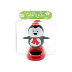 Solar Dancing Christmas Dashboard Toy featuring a cheerful penguin wobbler with a hat and scarf.