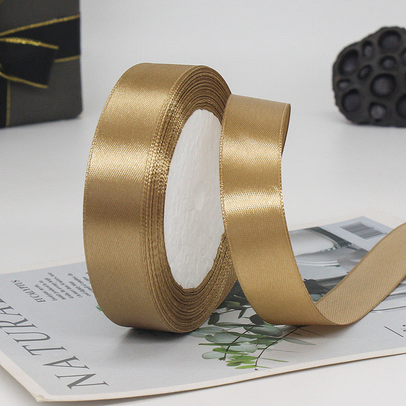 🧵 Premium Satin Ribbon – Versatile & Elegant in luxurious gold color on a crafting surface.