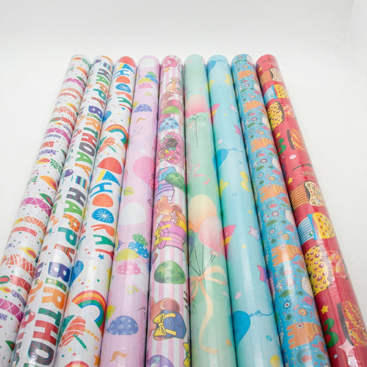 Rolls of colorful birthday-themed gift wrap paper on a white background