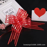 Pulling Ribbon(10PCS/3*47CM) in red decorative bow style displayed with a photo frame and heart card.