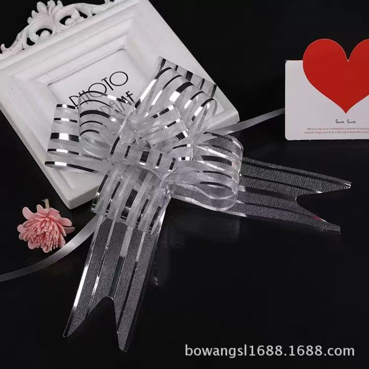 Pulling Ribbon(10PCS/3*47CM) featuring a decorative bow with silver stripes on a black background.