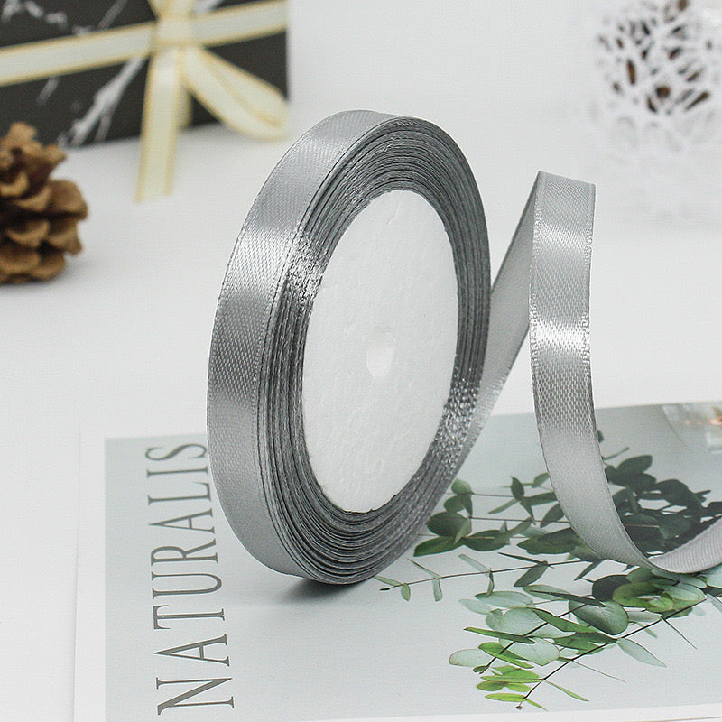 🧵 Premium Satin Ribbon – Versatile & Elegant displayed in a stylish setting with a bow and greenery accents.