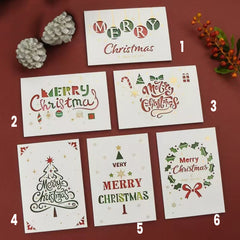 Collection of six Minimalist Christmas Greeting Cards on a flat surface surrounded by decorations.